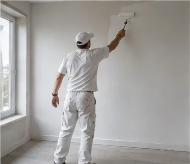 Maler streicht eine Wand mit der Rolle